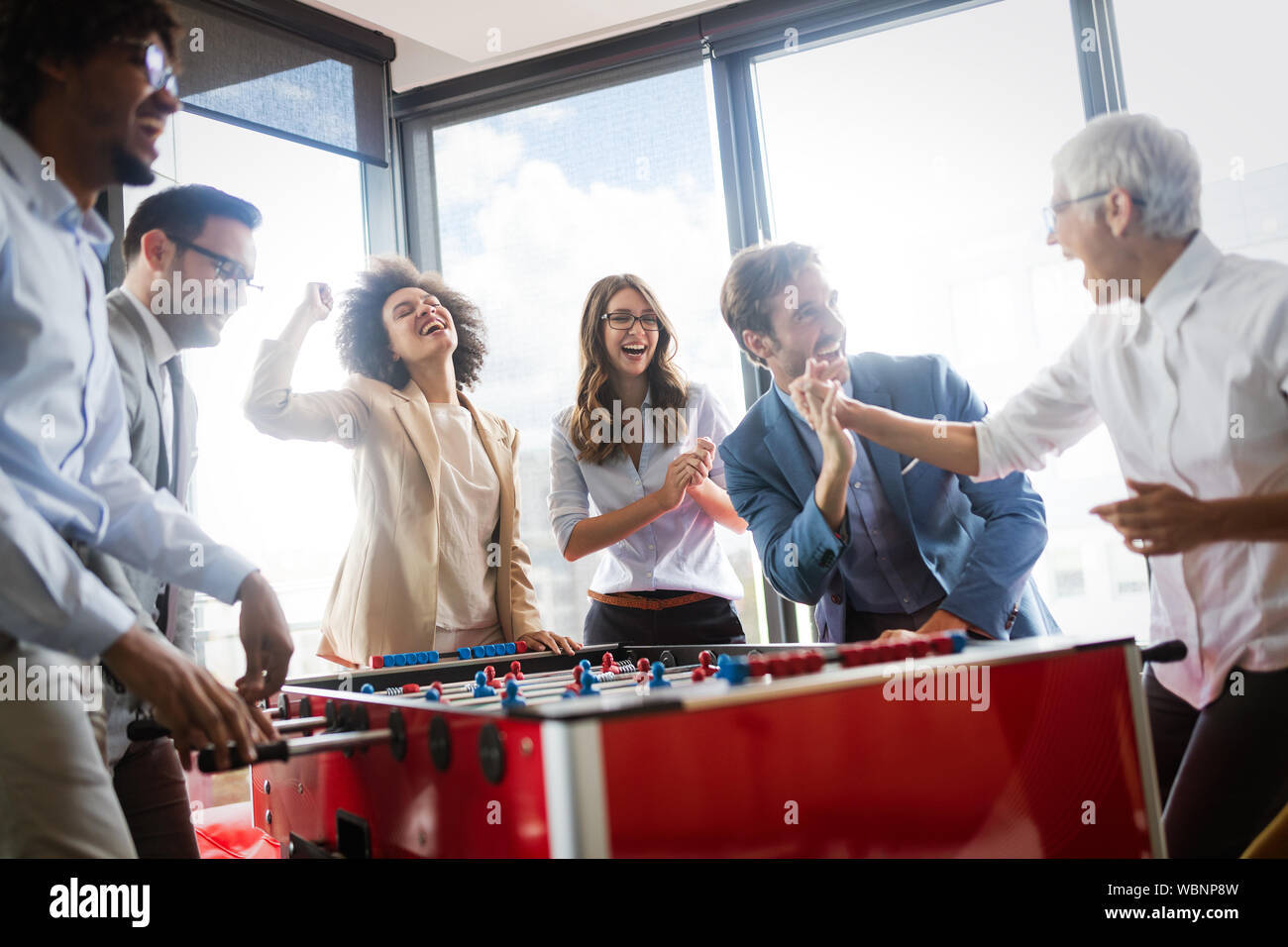 Multikulturellen Menschen feiern gewinnen beim Spielen Tischfußball Stockfoto