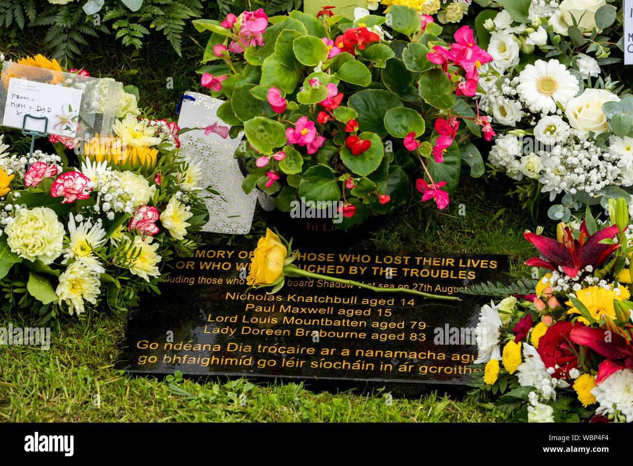 Die gelbe Rose von Maria, der Mutter der Hornsey Paul Maxwell, mit Kränzen und Blumen Rest am Denkmal Kreuz, mit Blick auf den Hafen von Mullaghmore, Co Sligo, zu denen, die vor 40 Jahren getötet wurden, als Herr MountbattenÕs Boot in die Luft gesprengt wurde, die von der IRA, vor der Küste von mullaghmore am 27. August 1979. Stockfoto