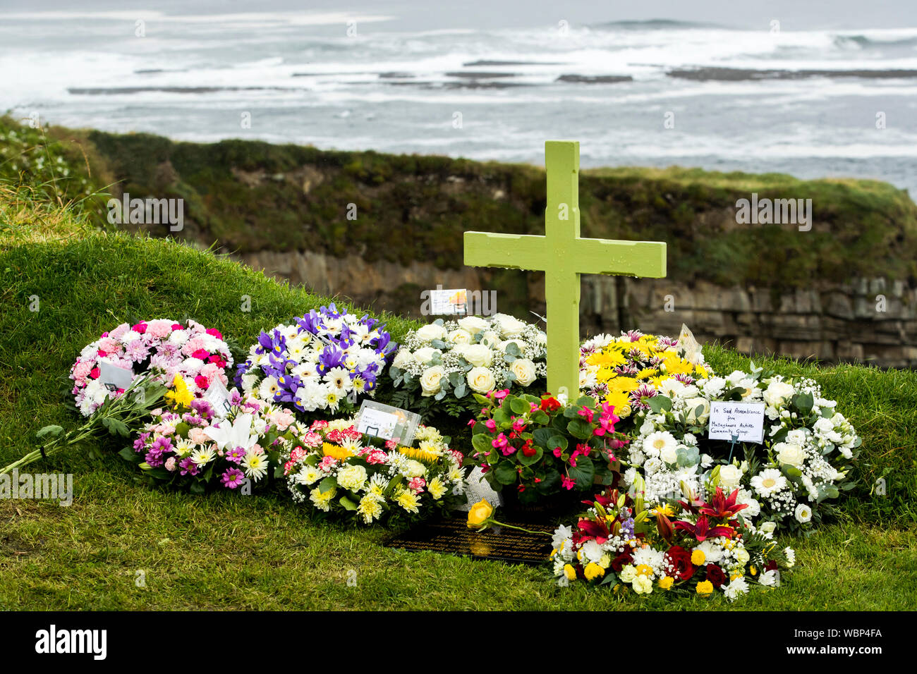 Kränze und Blumen am Denkmal Kreuz, mit Blick auf den Hafen von Mullaghmore, Co Sligo, zu denen, die vor 40 Jahren getötet wurden, als Herr MountbattenÕs Boot in die Luft gesprengt wurde, die von der IRA, vor der Küste von mullaghmore am 27. August 1979. Stockfoto