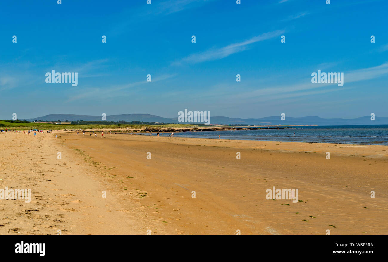 DORNOCH SUTHERLAND SCHOTTLAND MENSCHEN IM MEER UND AUF DEM weitläufigen Sandstrand von DORNOCH STRAND AN EINEM TAG IM SOMMER Stockfoto