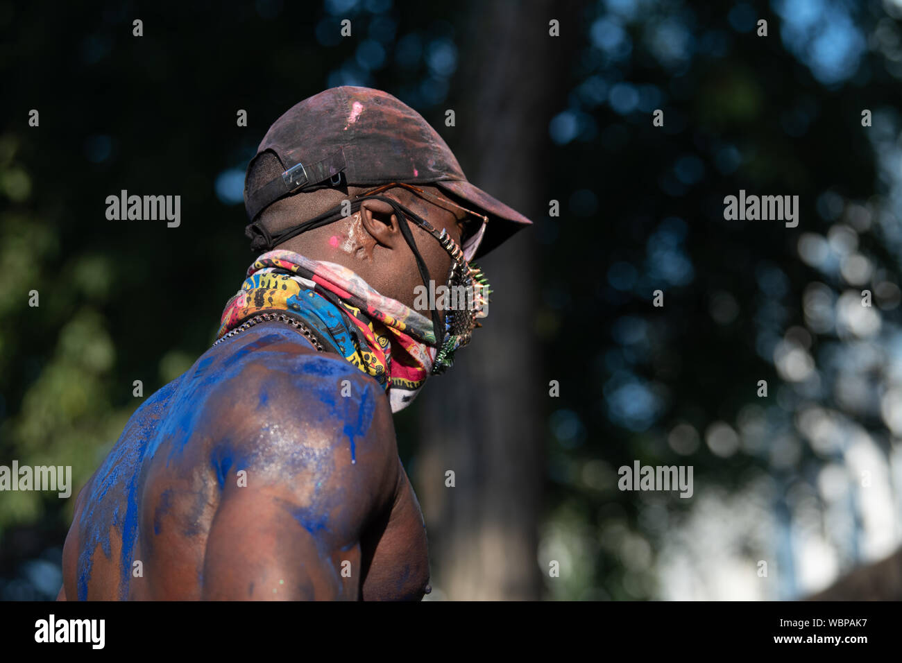 Ein schwarzer Mann bei Notting Hill Karneval in der blauen Farbe bedeckt. Stockfoto