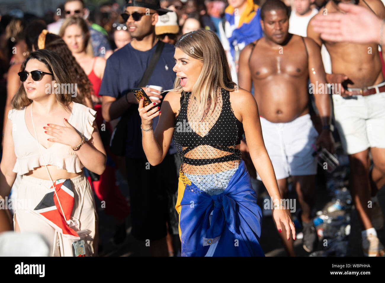 Eine Frau sehen, etwas in der Menschenmenge beim Karneval in Notting Hill, London, UK Stockfoto