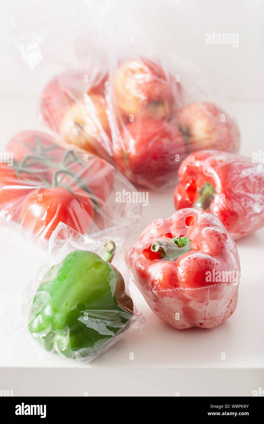 Single use Kunststoffverpackungen. Peperoni Tomaten äpfel Gemüse in Plastiktüten Stockfoto