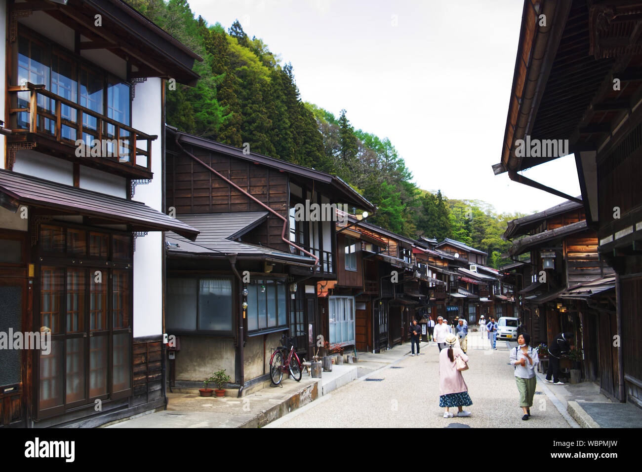 Besucher schlendern Sie entlang der Hauptstraße in Narai, eine Stadt auf der Nakasendo Trail in Japan, mit hölzernen Gebäuden gesäumt Stockfoto