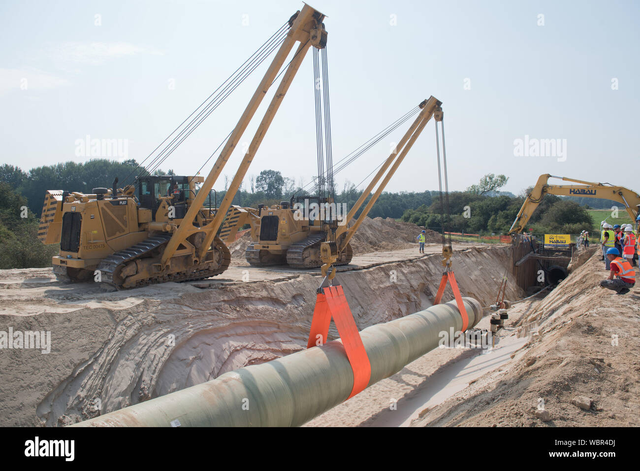 Mecklenburg, Deutschland. 27 Aug, 2019. Groß Polzin: ein Teil des Eugal Erdgas Pipeline (European Gas Pipeline Link) wird in die Peene Tunnel mit Hilfe der seitlichen Ausleger Krane festgelegt. Unter der Peene und ein Naturschutzgebiet, Gascade einen Tunnel drei Meter Durchmesser, durch die die eigentliche Pipeline am gleichen Tag gezogen wird gebohrt. In Zukunft wird die Pipeline Russisches Erdgas von Lubmin in Mecklenburg-Vorpommern in der Tschechischen Republik. Quelle: dpa Picture alliance/Alamy leben Nachrichten Stockfoto