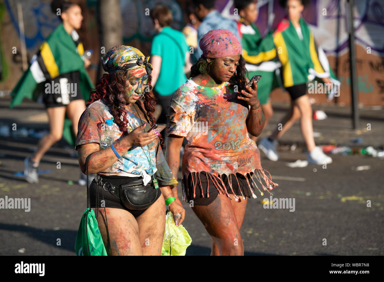 Eine Gruppe von Frauen ein Spaziergang durch Notting Hill Carnival in Farbe mit ihren Freunden. Stockfoto