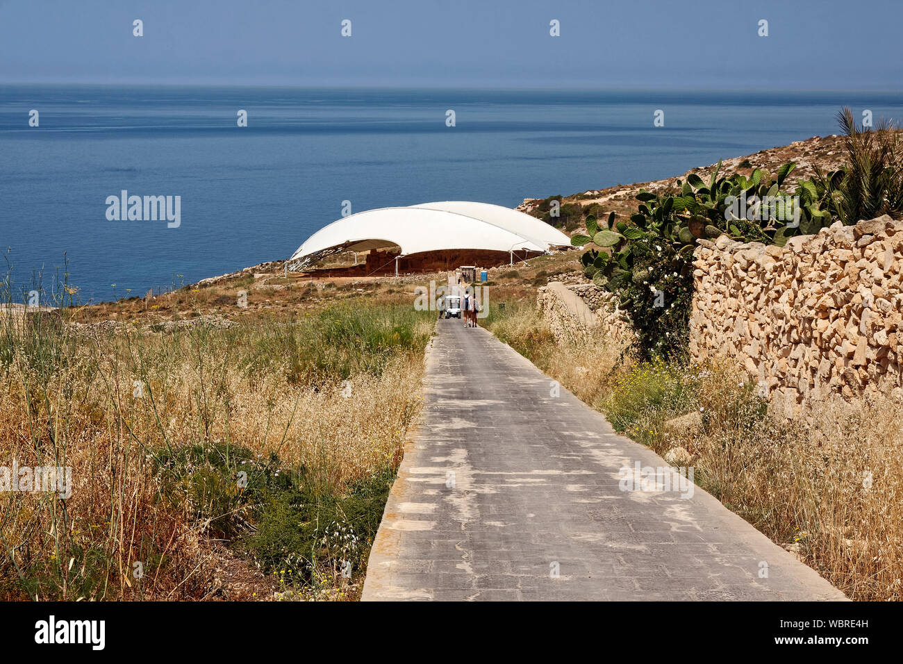 Mnajdra neolithische Tempel Ruinen, Schutzhülle, Mittelmeer, gepflasterter Weg, Menschen Wandern, Golf Warenkorb Transport, Europa; Qrendi; Malta; s Stockfoto