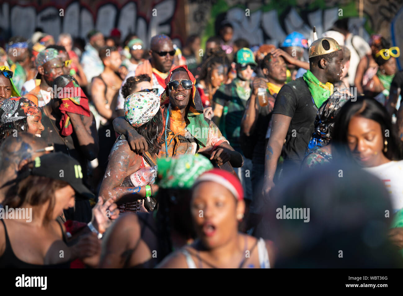 Eine große Masse von Menschen in Notting Hill Karneval zusammen tanzen, während in bunten Farbe bedeckt. Stockfoto