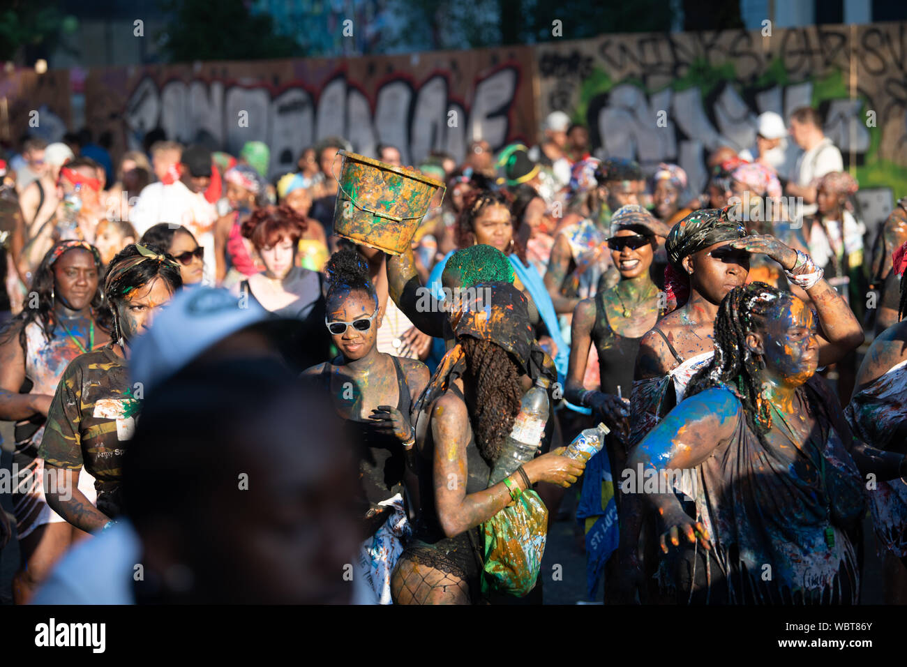 Eine große Masse von Menschen in Notting Hill Karneval zusammen tanzen, während in bunten Farbe bedeckt. Stockfoto