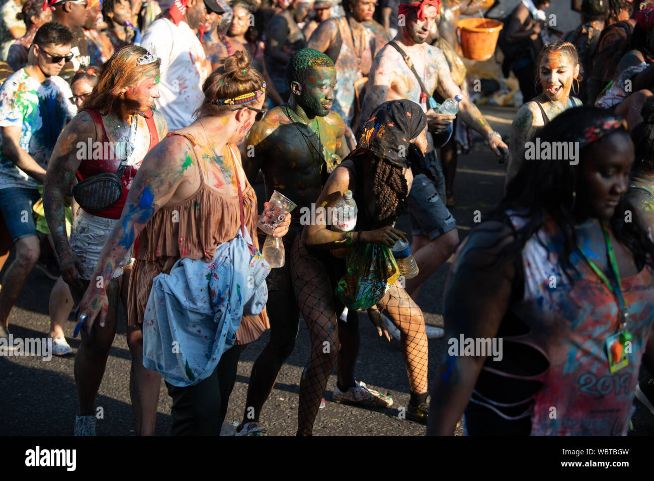 Eine große Masse von Menschen in Notting Hill Karneval zusammen tanzen, während in bunten Farbe bedeckt. Stockfoto