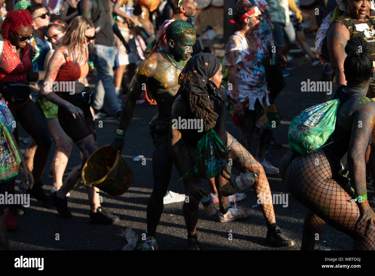 Eine große Masse von Menschen in Notting Hill Karneval zusammen tanzen, während in bunten Farbe bedeckt. Stockfoto