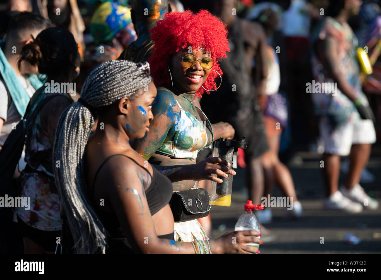 Eine Gruppe von Frauen an der Notting Hill Carnival tanzen in einer Masse von Menschen in Lack überzogen. Stockfoto