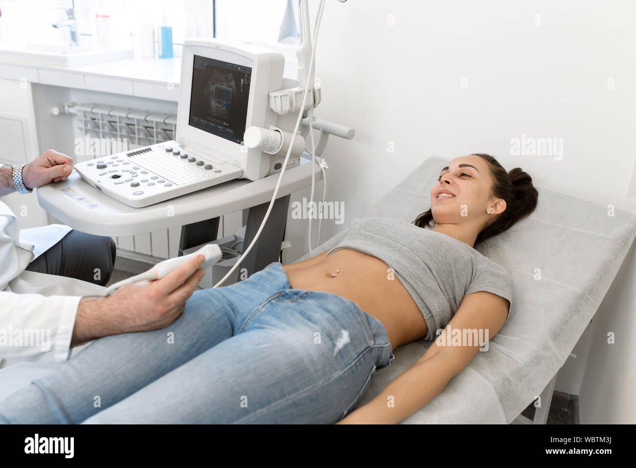Junge Frau in 4D Ultraschall. Die Ultraschalldiagnostik, die Untersuchung des Abdomens. Stockfoto