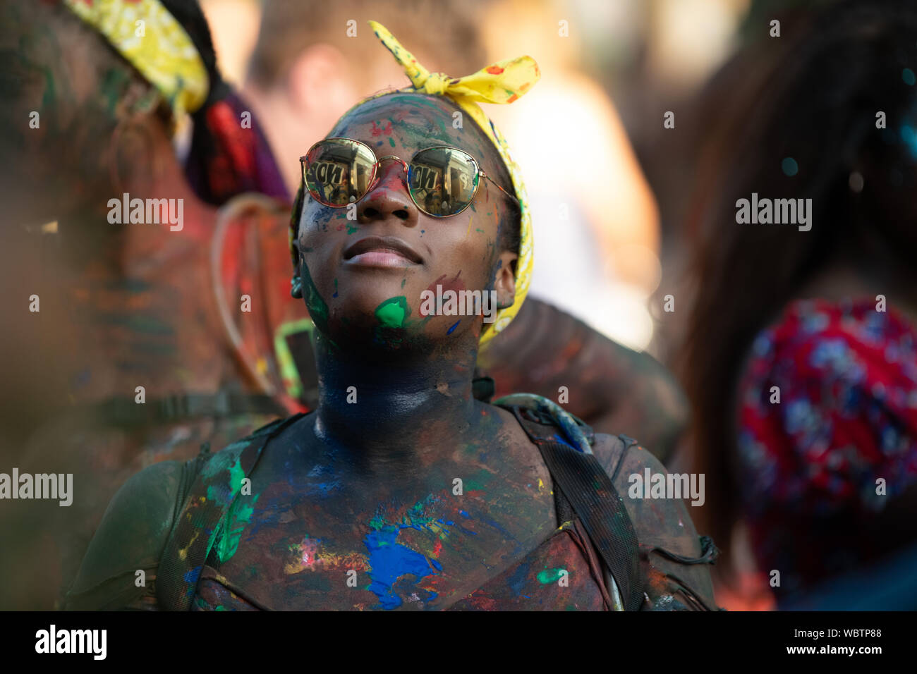 Eine schwarze Frau in Notting Hill Carnival abgedeckt in der Farbe. Stockfoto