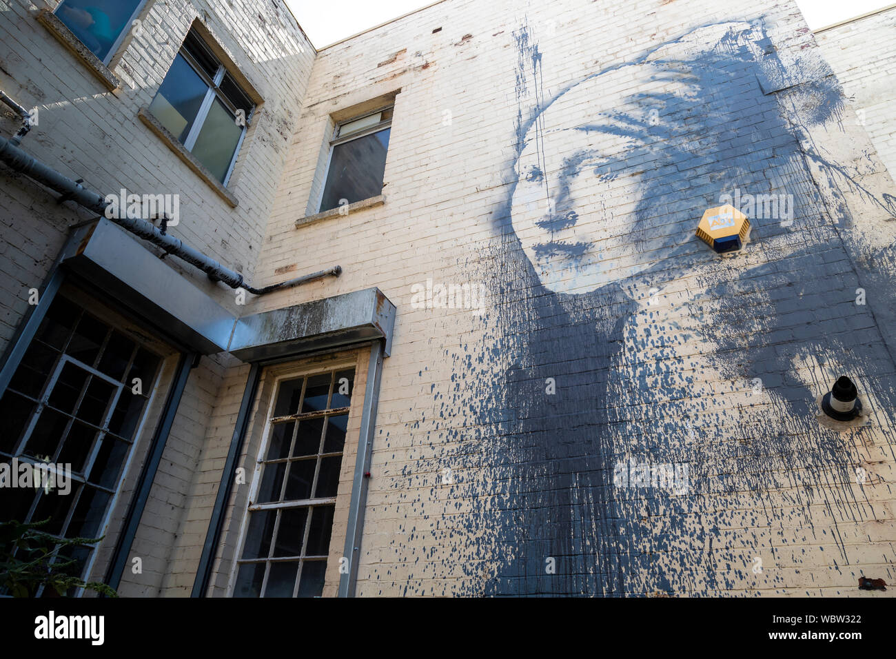 Ein banksy Wandmalerei, "Das Mädchen mit dem durchbohrten Trommelfell' auf ein Gebäude in Bristol, England Stockfoto