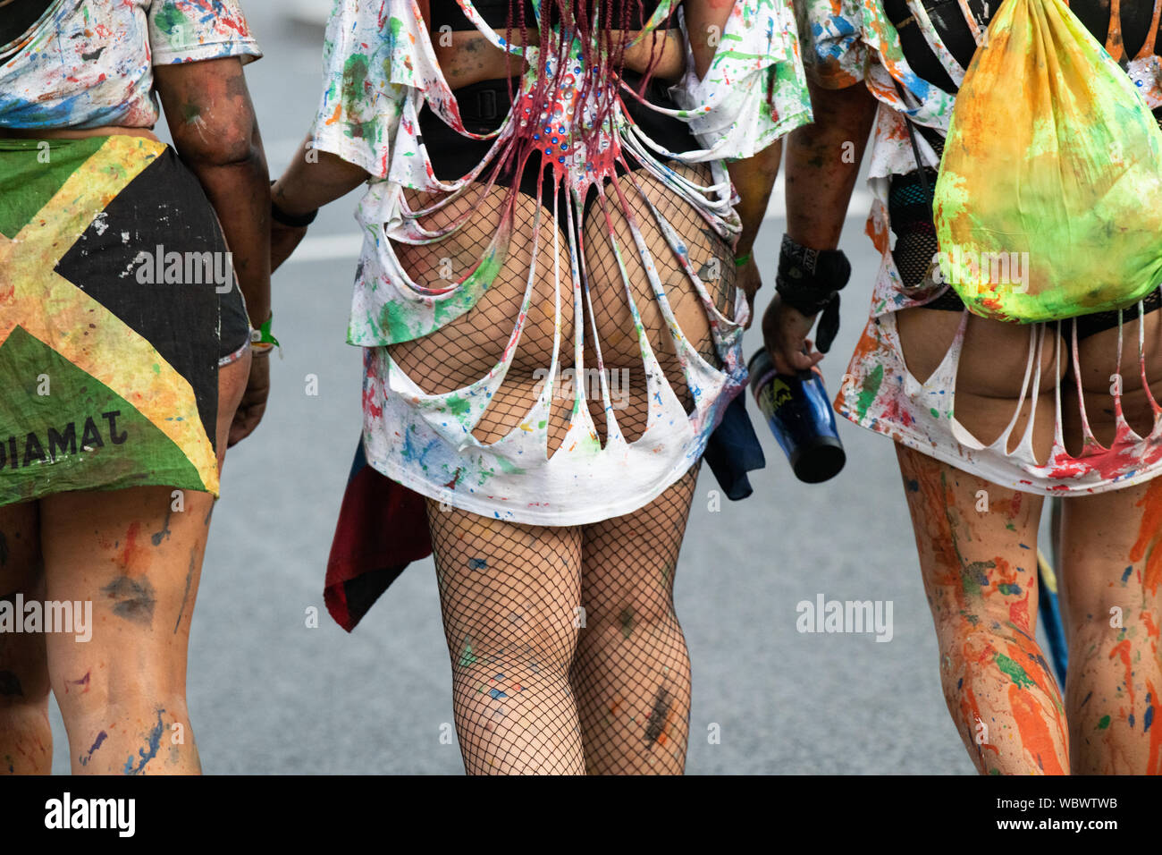 Rückseite der Notting Hill Carnival Darsteller bedeckt mit Farbe, wie Sie den Karneval verlassen. Stockfoto