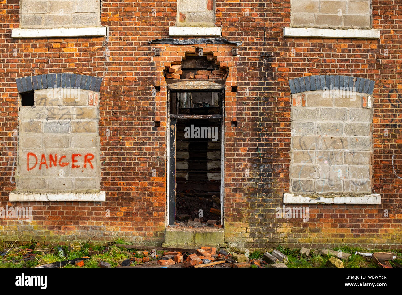 Zugemauert windows mit Gefahr schreiben auf verfallene Gebäude UK Stockfoto