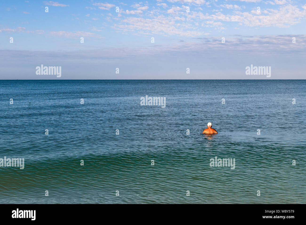 Älterer Mann Schwimmen im Meer und Horizont, Barefoot Beach anzeigen Stockfoto