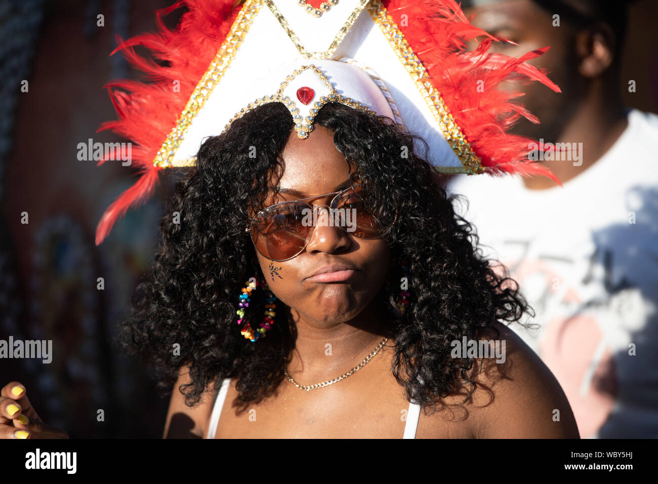 Performerin gekleidet in bunten Federn am Notting Hill Carnival, größte Karneval in Europa. Stockfoto