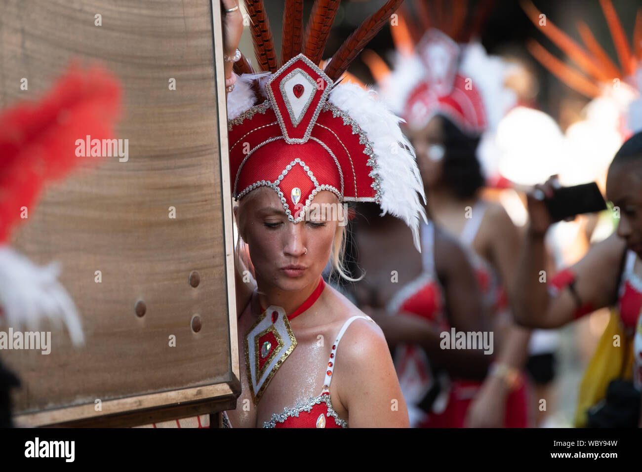 Performerin gekleidet in bunten Federn am Notting Hill Carnival, größte Karneval in Europa. Stockfoto