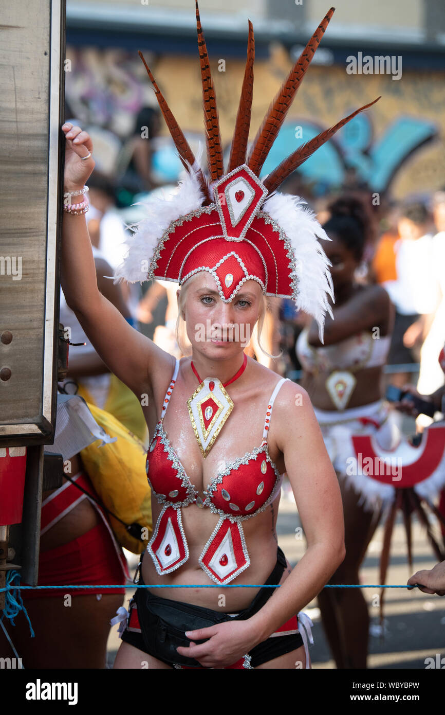 Performerin gekleidet in bunten Federn am Notting Hill Carnival, größte Karneval in Europa. Stockfoto