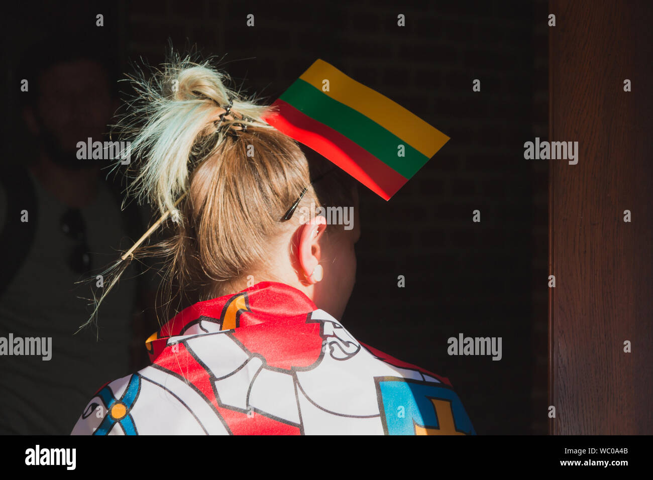 Junge Frau mit aufgeklebt, litauischer Flagge in Haaren Stockfoto