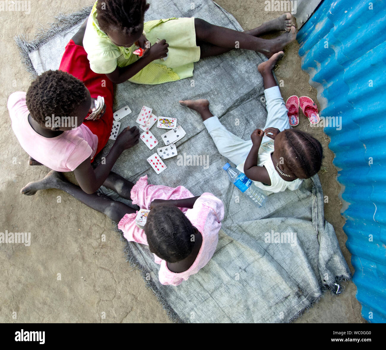 BOR, SOUTH SUDAN - 25. FEBRUAR 2013: Nicht identifizierte Kinder spielen Kartenspiele auf dem Boden im Süden des Sudan, Ansicht von oben Stockfoto