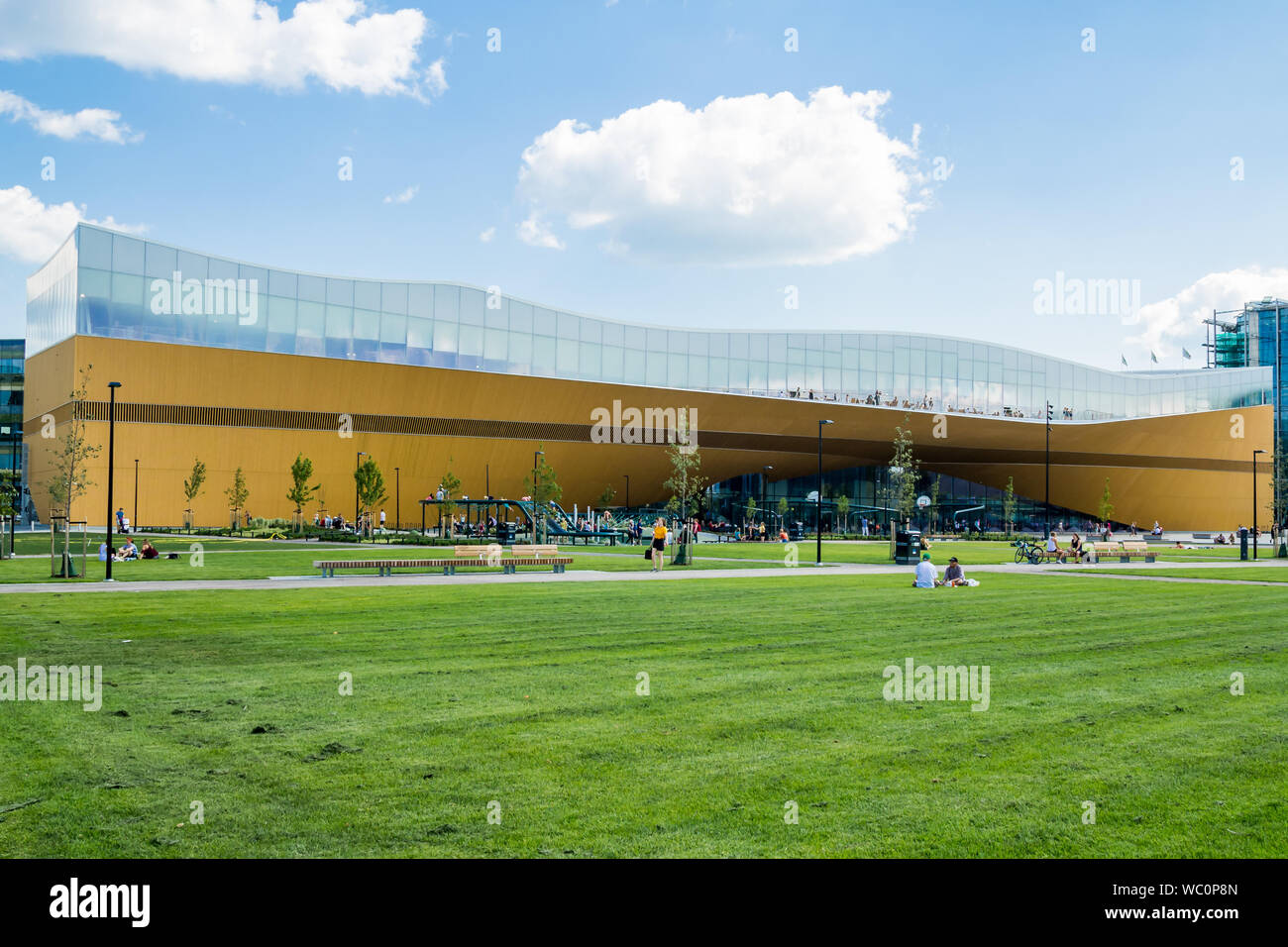 Helsinki, Finnland - Central Library Oodi - Die gesamte Fassade gesehen über frisch grünes Gras schneiden Stockfoto