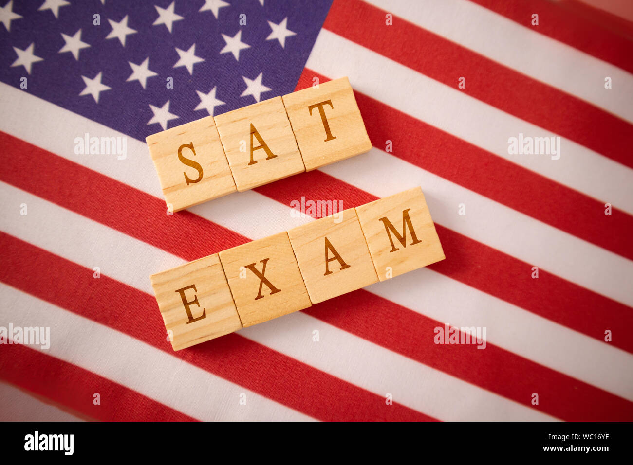 SAT Prüfung in Holzblock Buchstaben auf der US-Flagge. Stockfoto