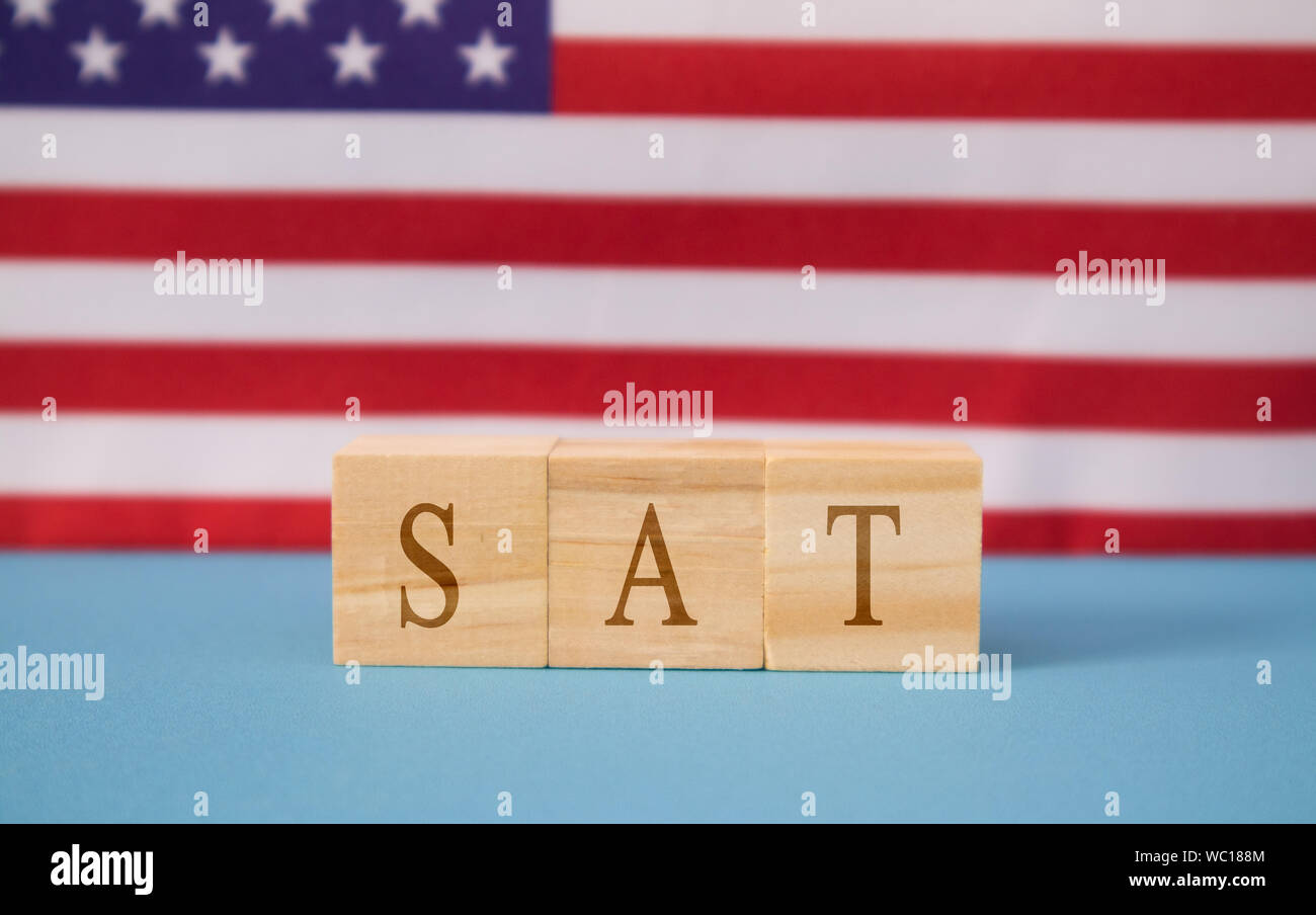 SAT Prüfung in Holzblock Buchstaben auf der US-Flagge. Stockfoto