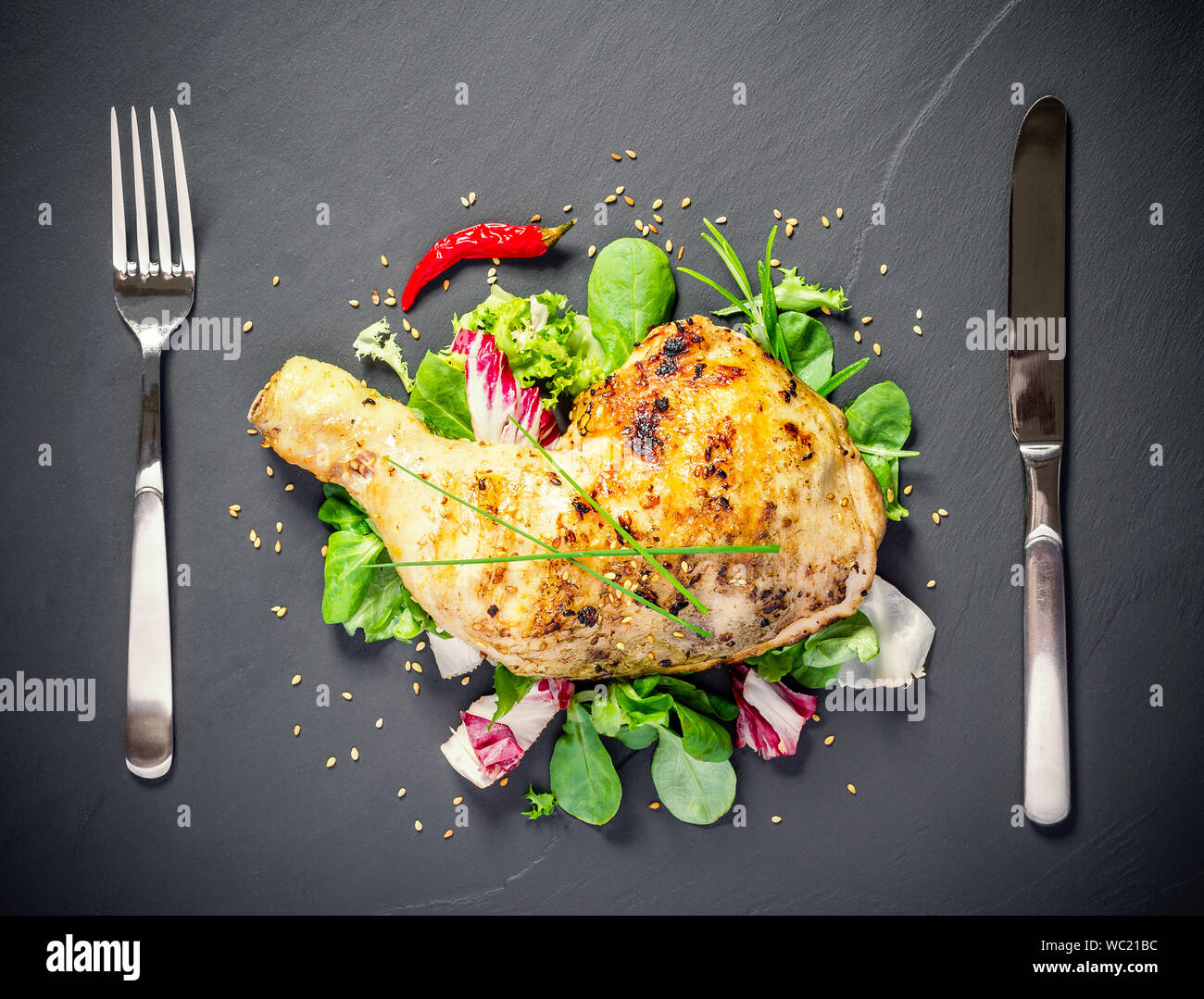 Gegrilltes Hähnchen Schenkel auf schiefer Platte, Ansicht von oben Stockfoto