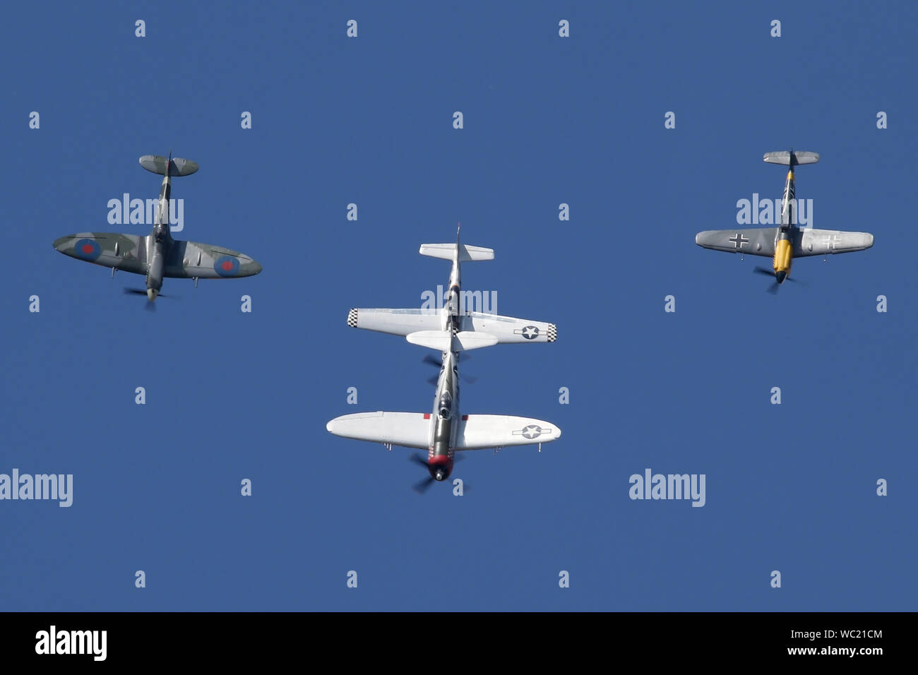 Der "Historischen Fighters' Team von 4 Weltkrieg zwei Kämpfer, P-51, P-47, Spitfire und Buchon in Formation overhead Wattisham Flugplatz. Stockfoto