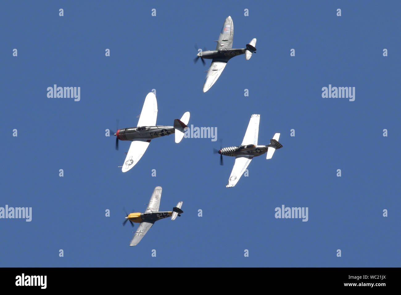 Der "Historischen Fighters' Team von 4 Weltkrieg zwei Kämpfer, P-51, P-47, Spitfire und Buchon in Formation overhead Wattisham Flugplatz. Stockfoto