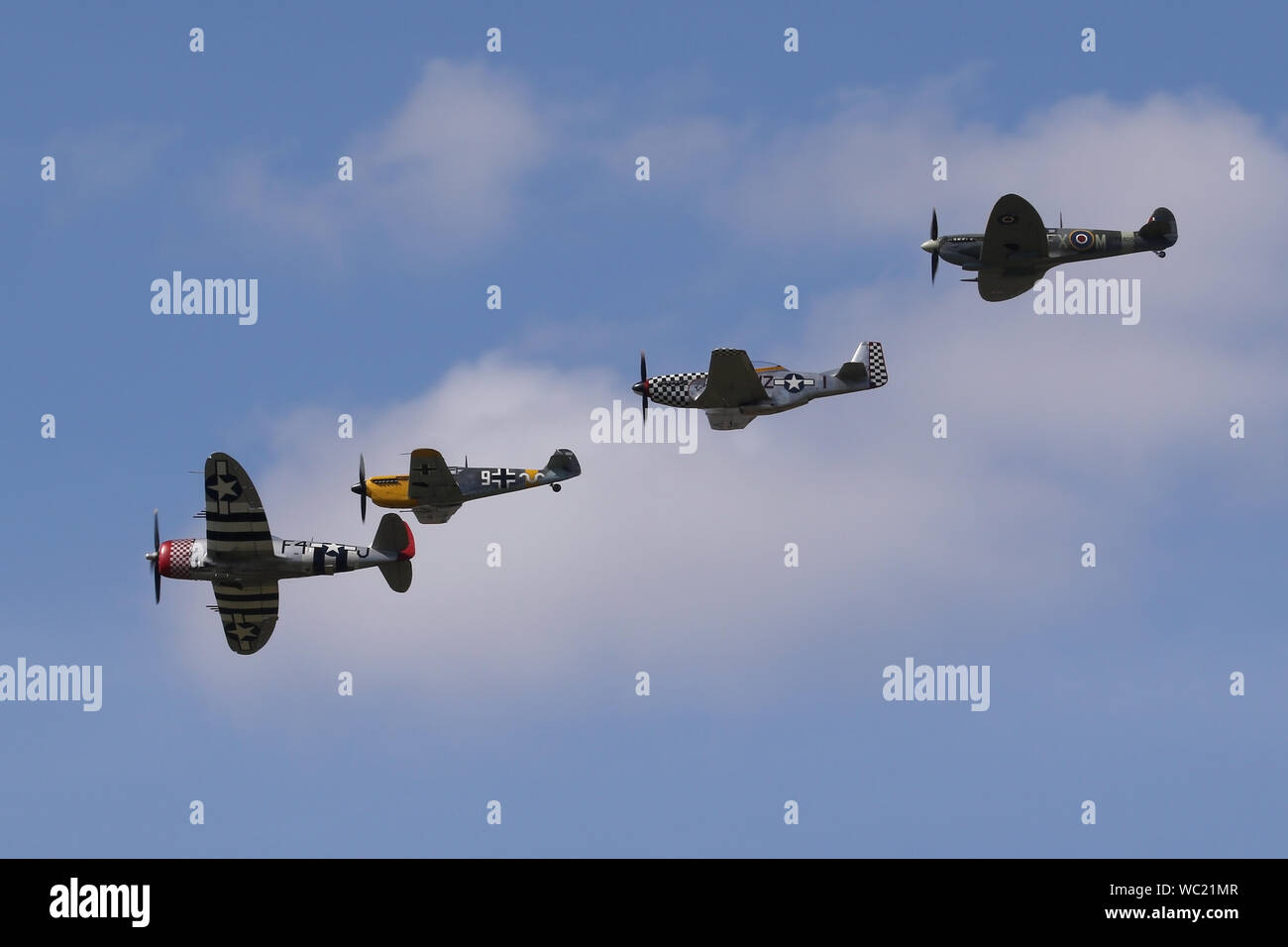 Der "Historischen Fighters' Team von 4 Weltkrieg zwei Kämpfer, P-51, P-47, Spitfire und Buchon in Formation overhead Wattisham Flugplatz. Stockfoto
