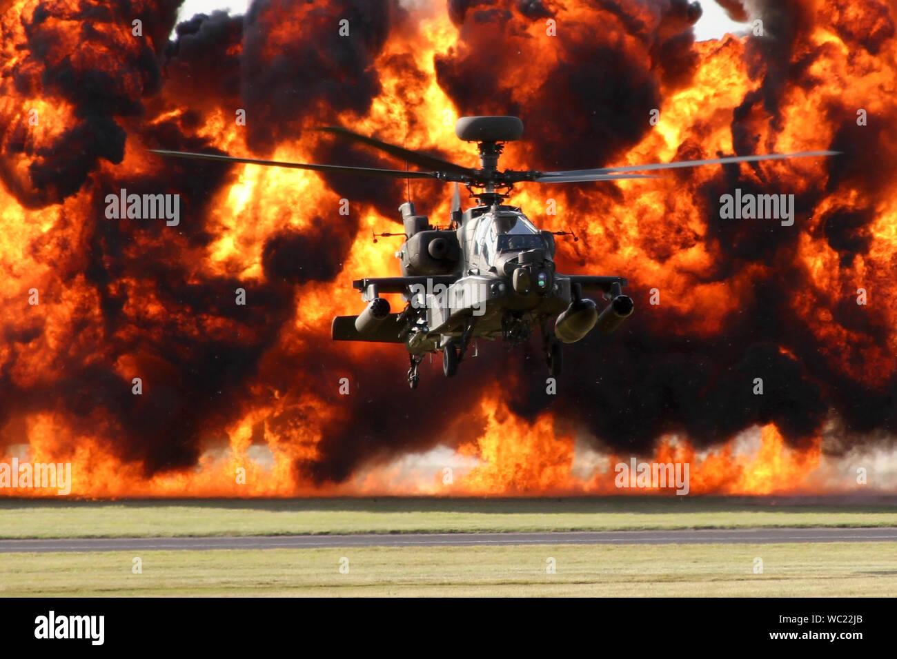 Army Air Corps Apache AH1 in der Hover mit einer Wand aus Feuer hinter zum Abschluss der Typen Rolle Demo in Wattisham, es ist home Station. Stockfoto