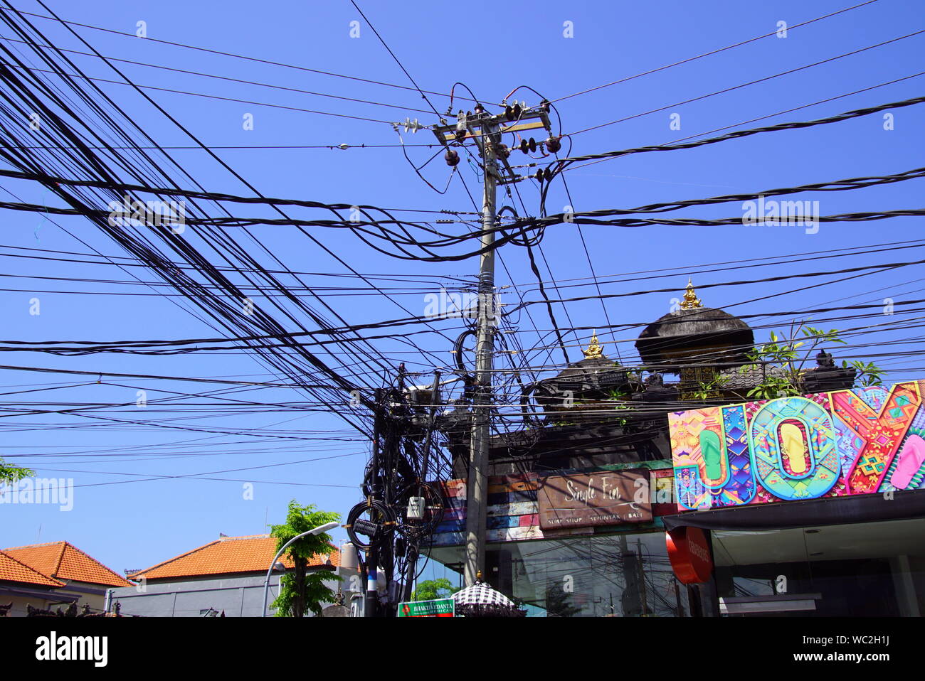 Legian, Bali, Indonesien - 13. August 2018: Messy Elektro und Telecom Kabel über eine Straße in Legian, Indonesien hängen. Stockfoto