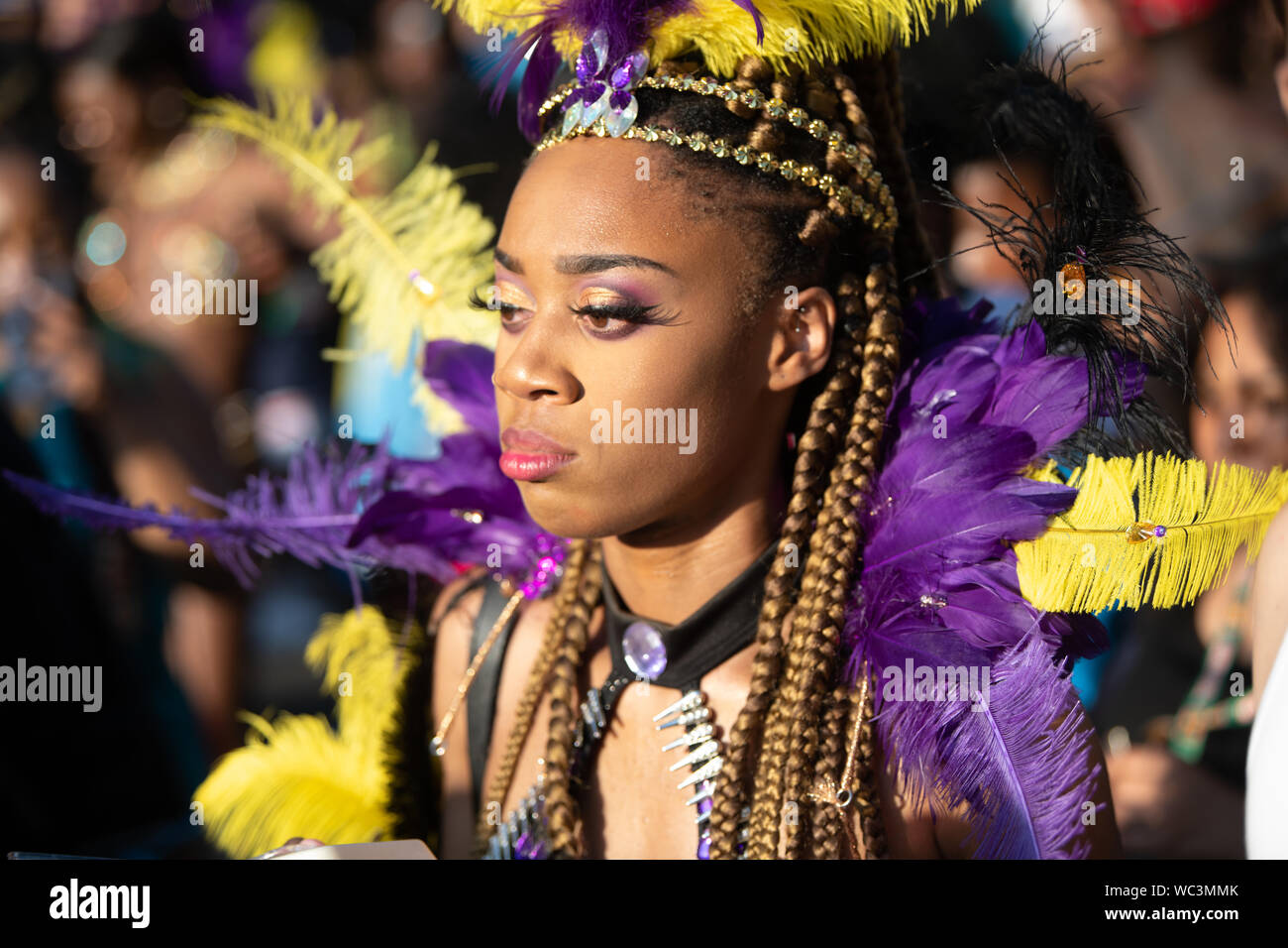 Performerin gekleidet in bunten Federn am Notting Hill Carnival, größte Karneval in Europa. Stockfoto