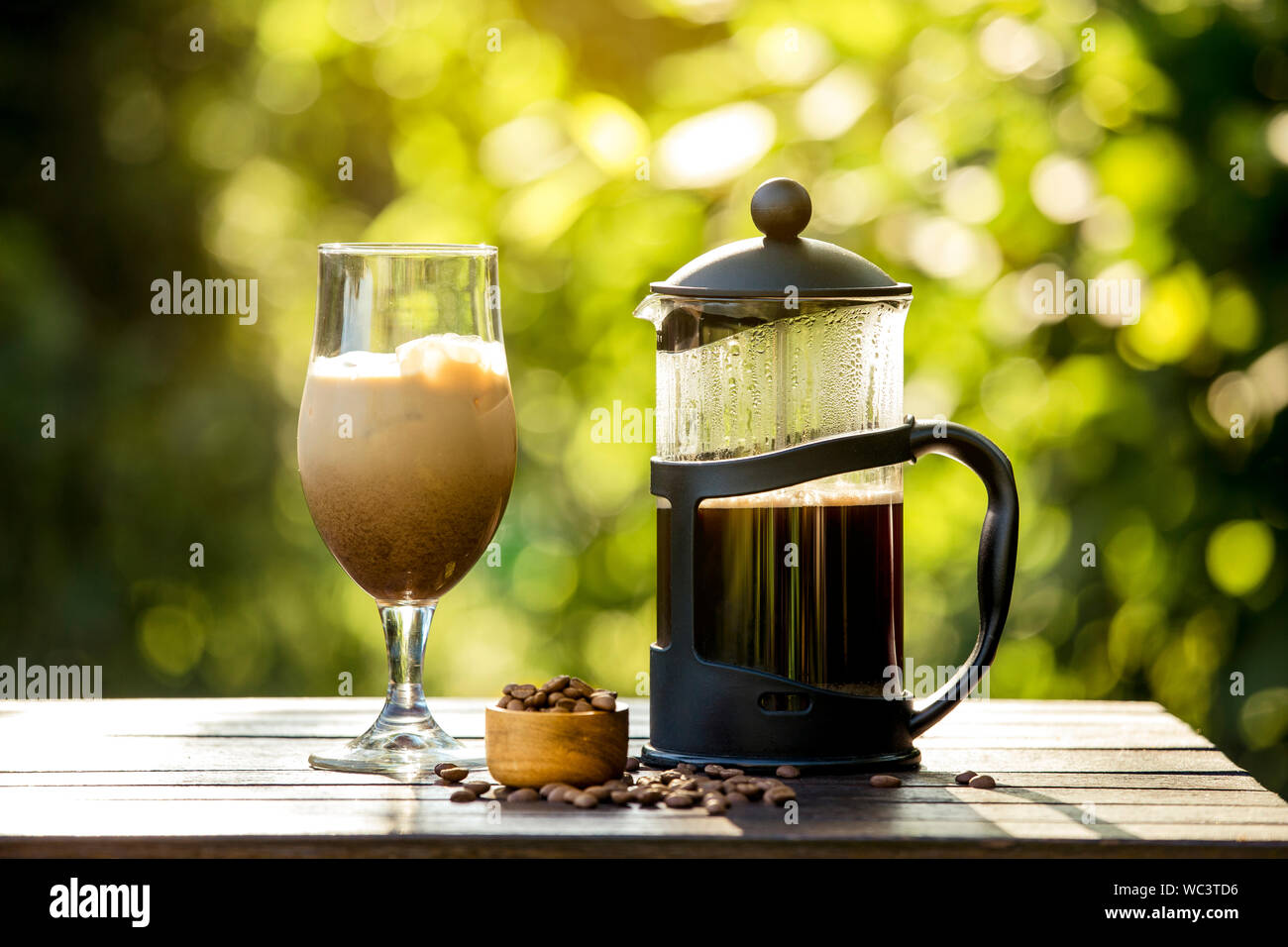 Selektiver Fokus auf Französische Presse Kaffeekanne und hausgemachte Eiskaffee, faulen Sonntag Morgen oder Abend mit kühlen Eiskaffee im Haus Garten, brechen. Werden Stockfoto
