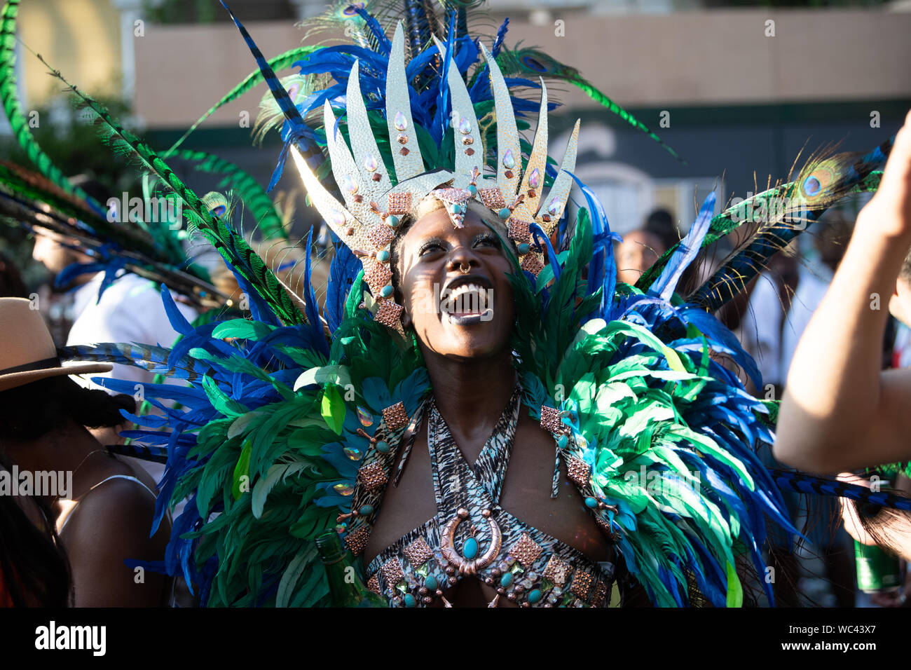 Performerin gekleidet in bunte Federn am Notting Hill Carnival, größte Karneval in Europa. Stockfoto