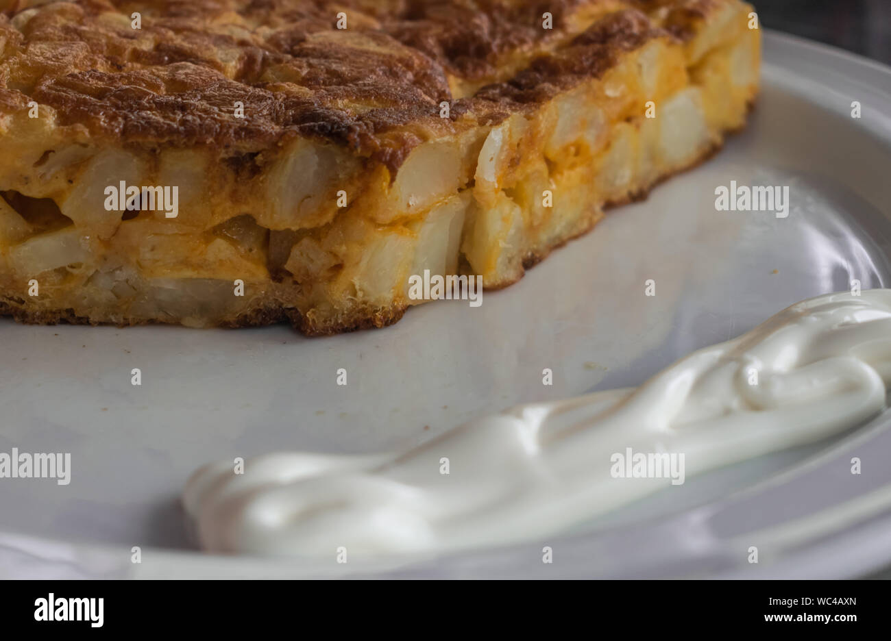 Spanisches Omelette mit Mayonnaise, auf einer weißen Platte Stockfoto