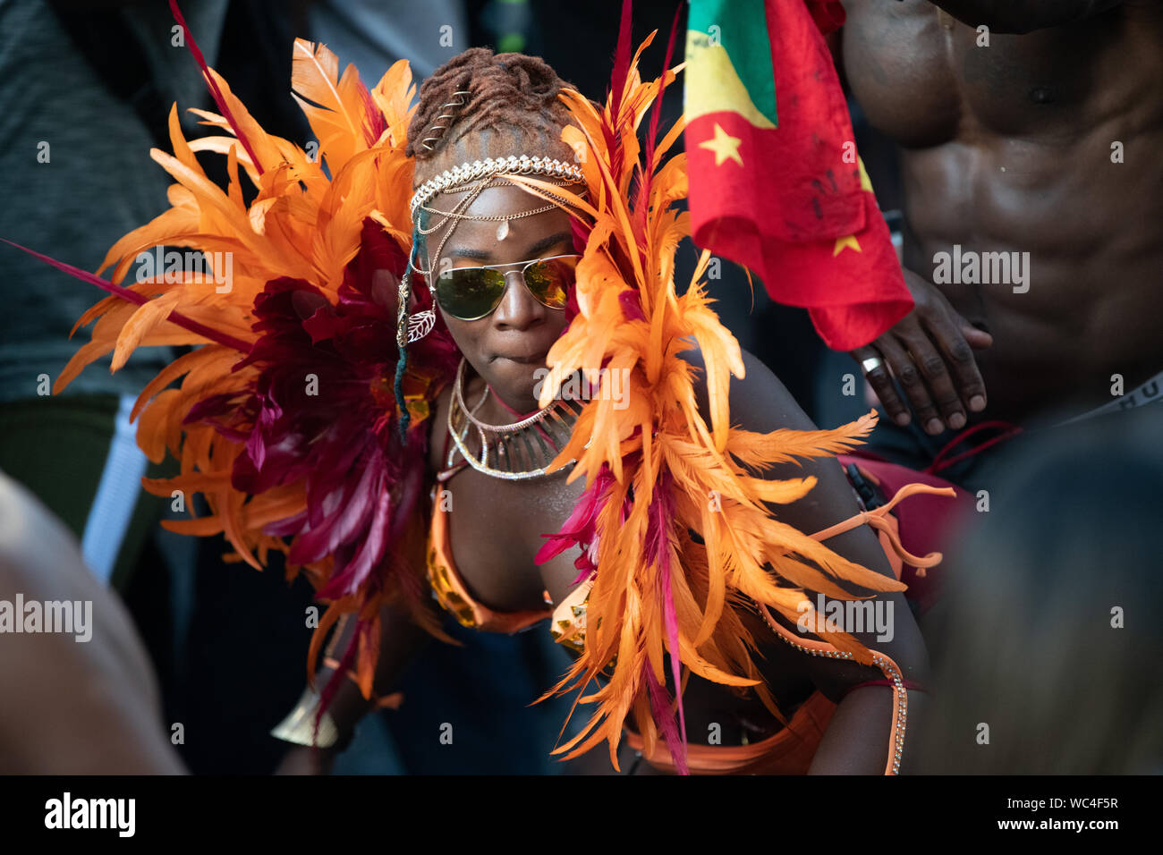 Performerin gekleidet in bunten Federn am Notting Hill Carnival, größte Karneval in Europa. Stockfoto
