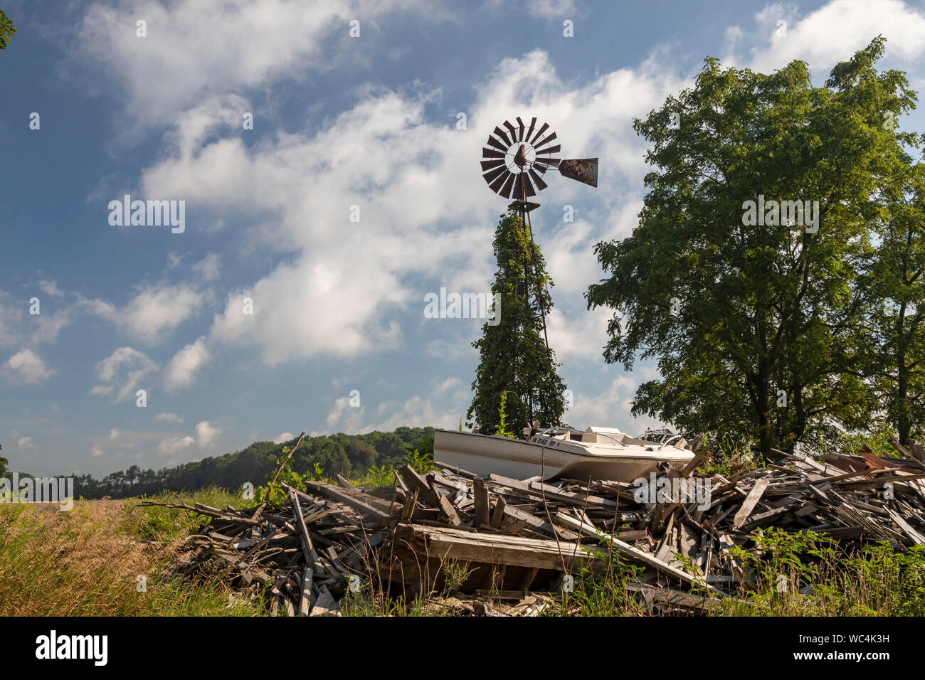 Drei Eichen, Michigan - Eine alte Windmühle auf einem Michigan Farm, in der Nähe der Überreste einer Farm House und eine weggeworfene Boot. Stockfoto