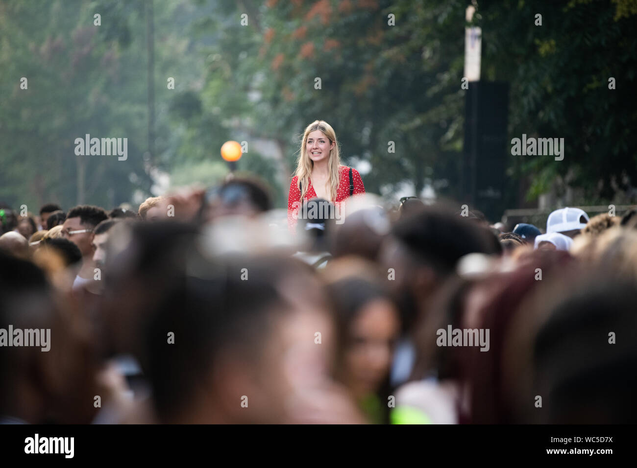 Frau über die Menge tragen Rot, Notting Hill Carnival 2019, London, UK Stockfoto