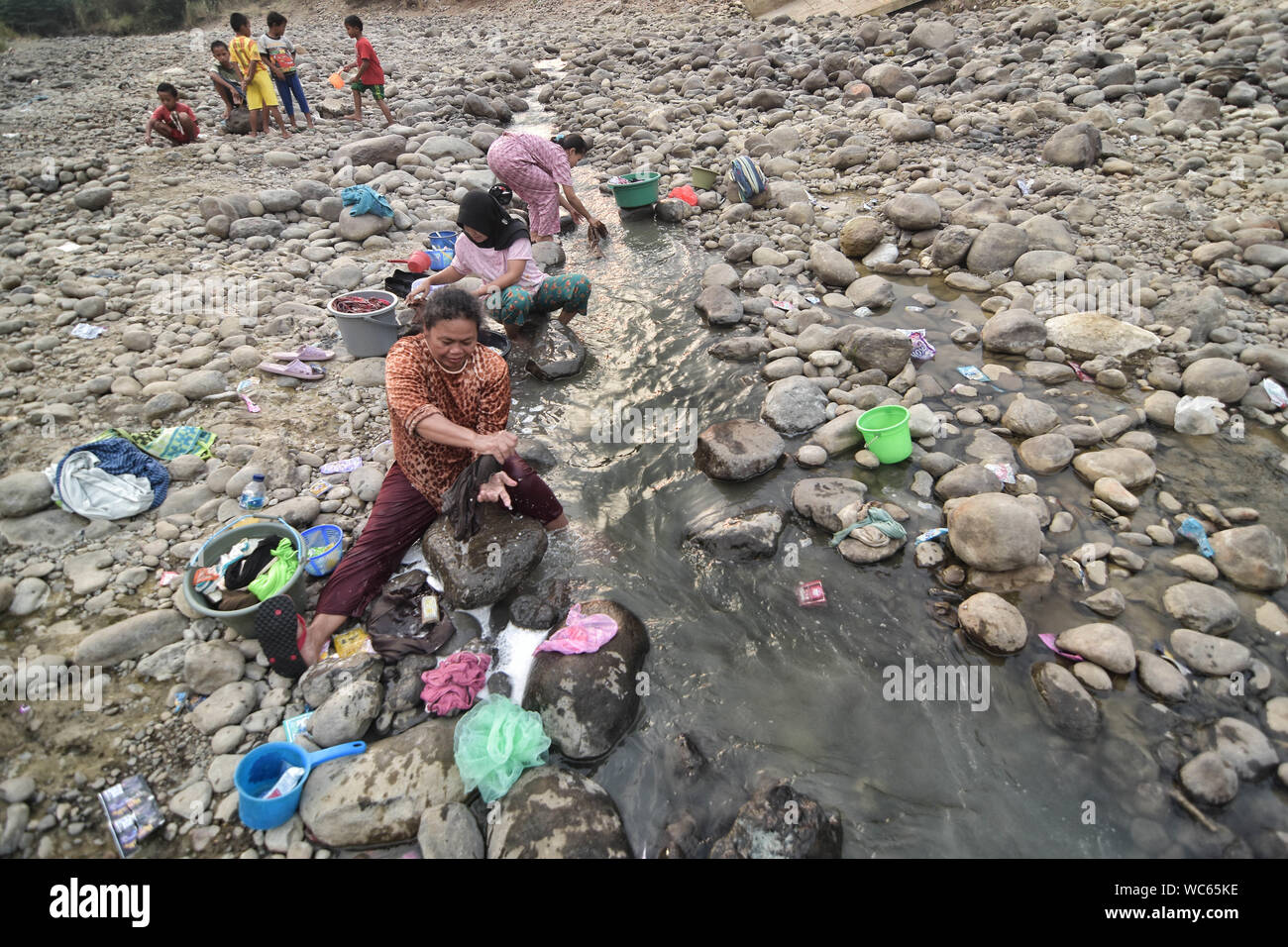 Bekasi, West Java, Indonesien. 27 Aug, 2019. Bewohner sammeln das Wasser aus einem trockenen Cipamingkis Fluss für den häuslichen Gebrauch als ihre Brunnen Austrocknen infolge der Trockenheit im Sommer. der Meteorologie, Klimatologie und Geophysik Agentur hat davor gewarnt, dass die trockene Jahreszeit kann trockener und intensiver als im letzten Jahr aufgrund der El NiÃ±o Phänomen. Die Agentur klassifiziert, West Java, Central Java, die meisten Teile von Ost Java, Jakarta, Bali und Nusa Tenggara, da der Bereich der meisten anfällig für extreme Dürre, oder mehr als 60 Tage ohne Regen. Credit: Agung Fatma Putra/SOPA Images/ZUMA Draht/Alamy leben Nachrichten Stockfoto