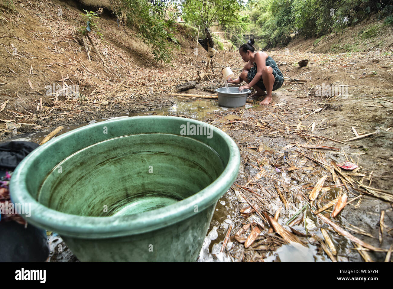 Bekasi, West Java, Indonesien. 27 Aug, 2019. Ein Bewohner sammelt das Wasser aus einem Einzugsgebiet gut am cihoe Fluss. Die Meteorologie, Klimatologie und Geophysik Agentur hat davor gewarnt, dass die trockene Jahreszeit kann trockener und intensiver als im letzten Jahr aufgrund der El NiÃ±o Phänomen. Die Agentur klassifiziert, West Java, Central Java, die meisten Teile von Ost Java, Jakarta, Bali und Nusa Tenggara, da der Bereich der meisten anfällig für extreme Dürre, oder mehr als 60 Tage ohne Regen. Credit: Agung Fatma Putra/SOPA Images/ZUMA Draht/Alamy leben Nachrichten Stockfoto