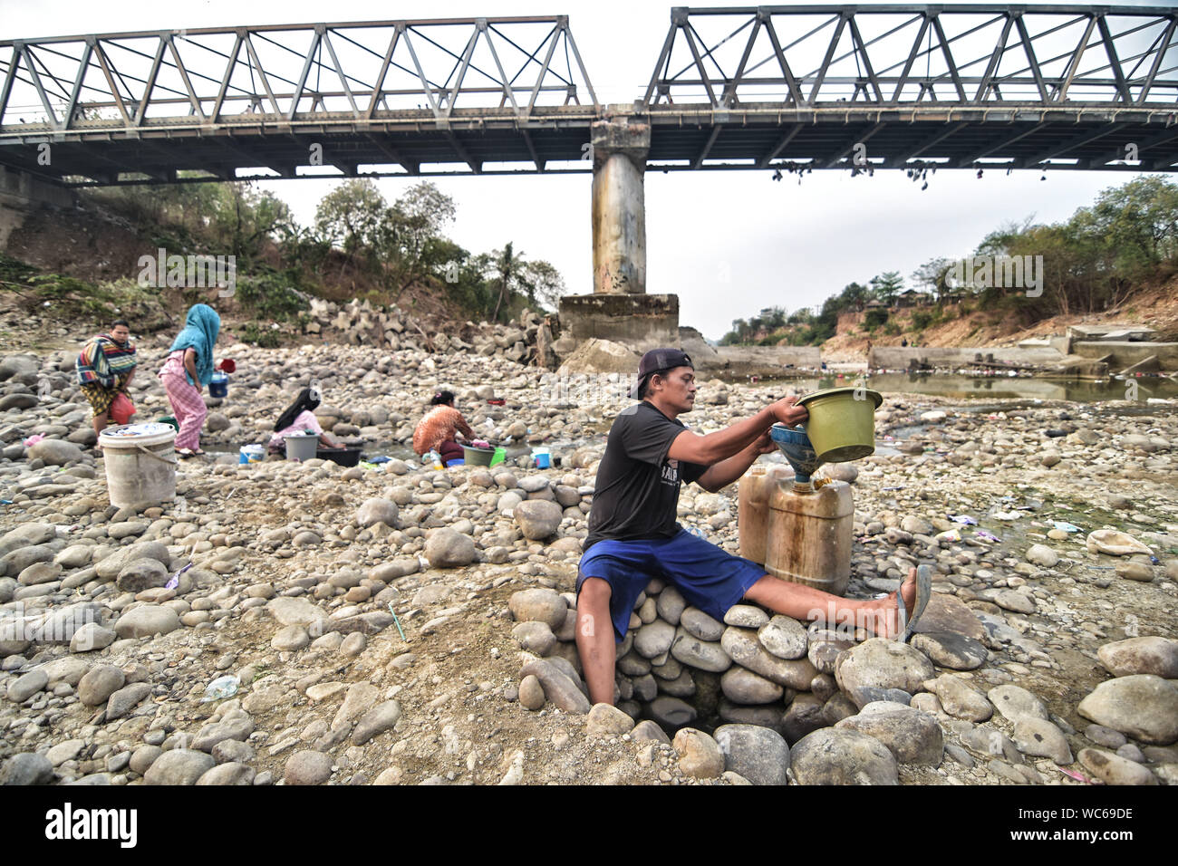Bekasi, West Java, Indonesien. 27 Aug, 2019. Bewohner sammeln das Wasser aus einem trockenen Cipamingkis Fluss für den häuslichen Gebrauch als ihre Brunnen Austrocknen infolge der Trockenheit im Sommer. der Meteorologie, Klimatologie und Geophysik Agentur hat davor gewarnt, dass die trockene Jahreszeit kann trockener und intensiver als im letzten Jahr aufgrund der El NiÃ±o Phänomen. Die Agentur klassifiziert, West Java, Central Java, die meisten Teile von Ost Java, Jakarta, Bali und Nusa Tenggara, da der Bereich der meisten anfällig für extreme Dürre, oder mehr als 60 Tage ohne Regen. Credit: Agung Fatma Putra/SOPA Images/ZUMA Draht/Alamy leben Nachrichten Stockfoto