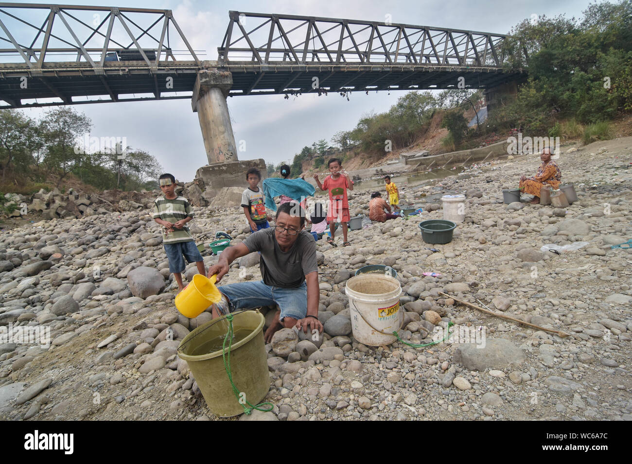 Bekasi, West Java, Indonesien. 27 Aug, 2019. Bewohner sammeln das Wasser aus einem trockenen Cipamingkis Fluss für den häuslichen Gebrauch als ihre Brunnen Austrocknen infolge der Trockenheit im Sommer. der Meteorologie, Klimatologie und Geophysik Agentur hat davor gewarnt, dass die trockene Jahreszeit kann trockener und intensiver als im letzten Jahr aufgrund der El NiÃ±o Phänomen. Die Agentur klassifiziert, West Java, Central Java, die meisten Teile von Ost Java, Jakarta, Bali und Nusa Tenggara, da der Bereich der meisten anfällig für extreme Dürre, oder mehr als 60 Tage ohne Regen. Credit: Agung Fatma Putra/SOPA Images/ZUMA Draht/Alamy leben Nachrichten Stockfoto