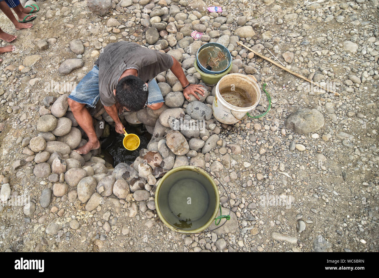 Bekasi, West Java, Indonesien. 27 Aug, 2019. Ein Bewohner sammelt das Wasser aus einem trockenen Cipamingkis Fluss für den häuslichen Gebrauch als ihre Brunnen Austrocknen infolge der Trockenheit im Sommer. der Meteorologie, Klimatologie und Geophysik Agentur hat davor gewarnt, dass die trockene Jahreszeit kann trockener und intensiver als im letzten Jahr aufgrund der El NiÃ±o Phänomen. Die Agentur klassifiziert, West Java, Central Java, die meisten Teile von Ost Java, Jakarta, Bali und Nusa Tenggara, da der Bereich der meisten anfällig für extreme Dürre, oder mehr als 60 Tage ohne Regen. Credit: Agung Fatma Putra/SOPA Images/ZUMA Draht/Alamy leben Nachrichten Stockfoto