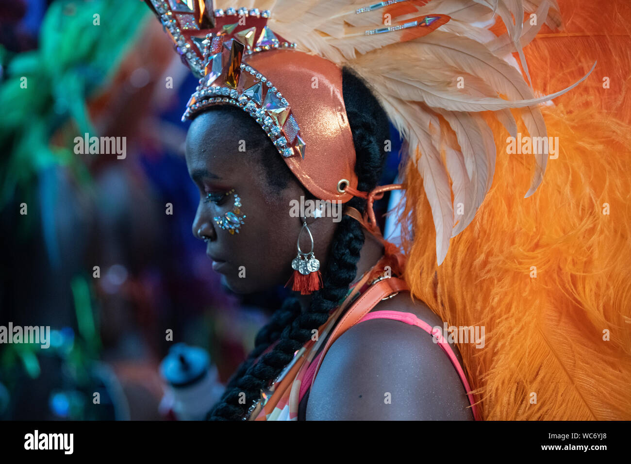 Tänzerin Federn tragen und sich an den Notting Hill Carnival in London, der größten Straße Karneval in Europa suchen Stockfoto
