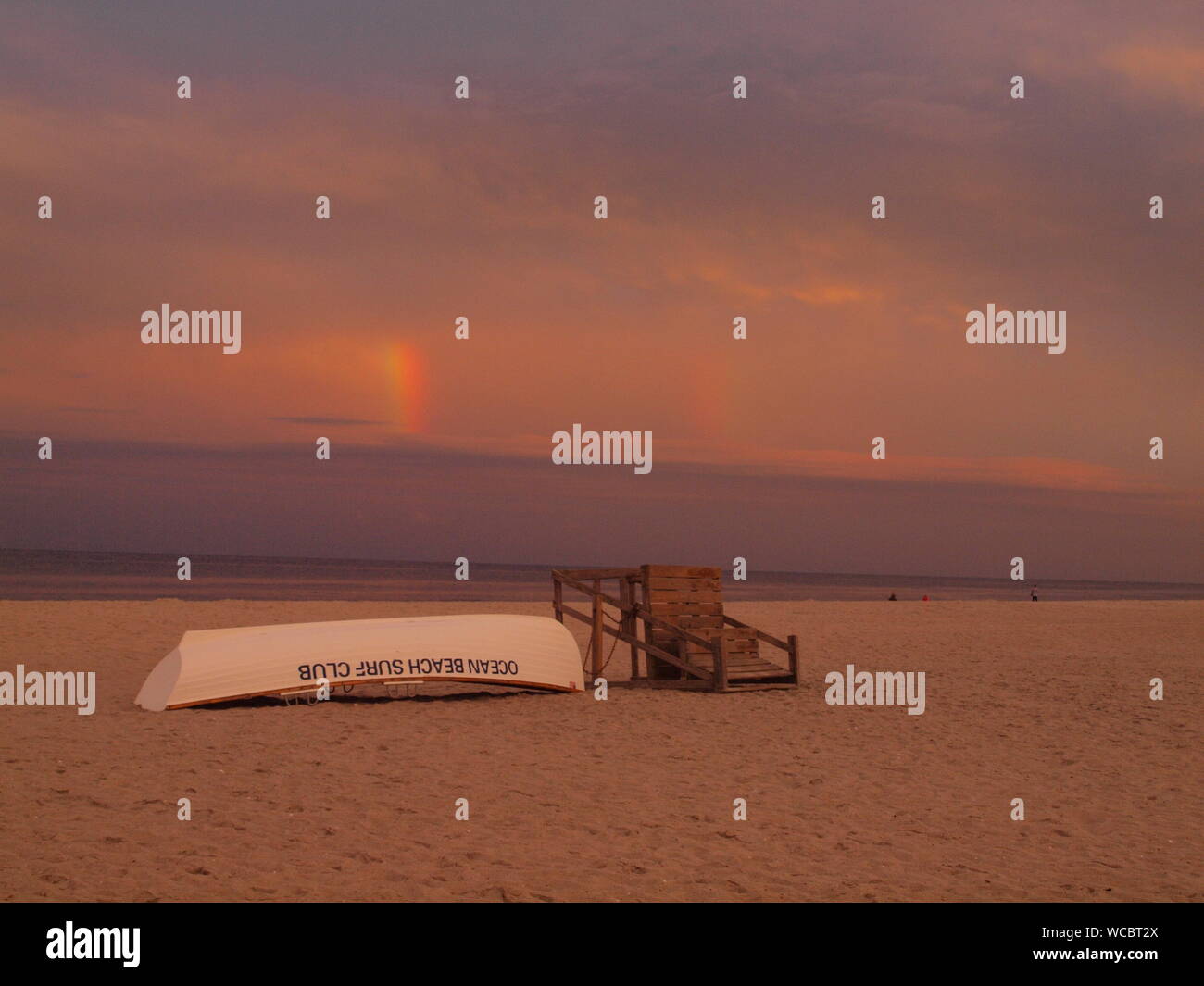 Regenbogen über dem Atlantik von Ocean Beach, New Jersey mit Rettungsschwimmer stehen und Rettungsboot im Vordergrund. Stockfoto
